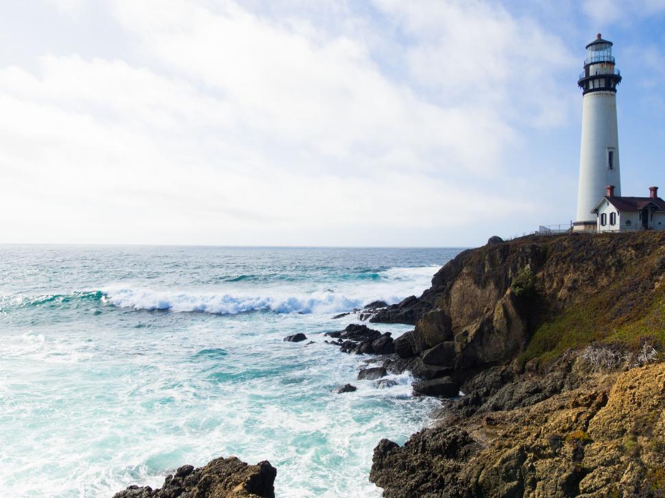 Free Image of Lighthouse on Cliff Overlooking Ocean 