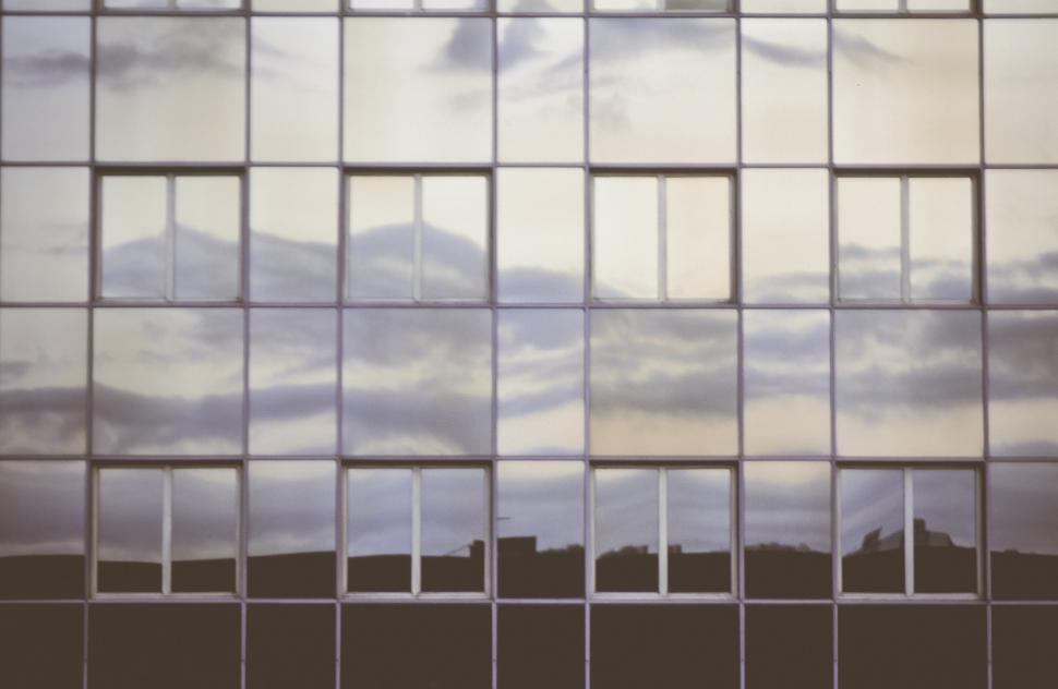 Free Image of Facade of office tower in front of blue sky 