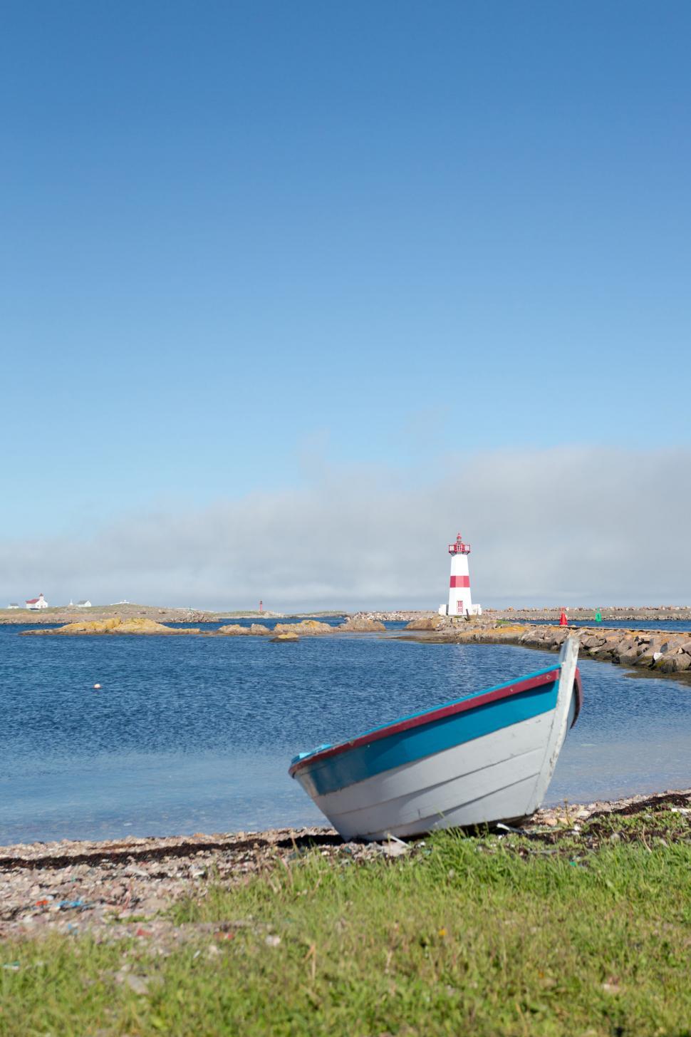 Free Image of Dory on a Beach with Lighthouse 