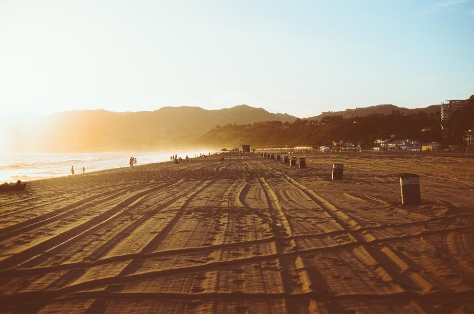 Free Image of People Walking on Sandy Beach 