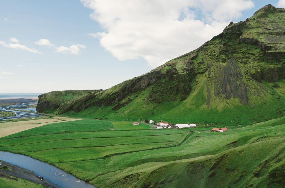 Free Image of Lush Green Hillside With River Running Through 
