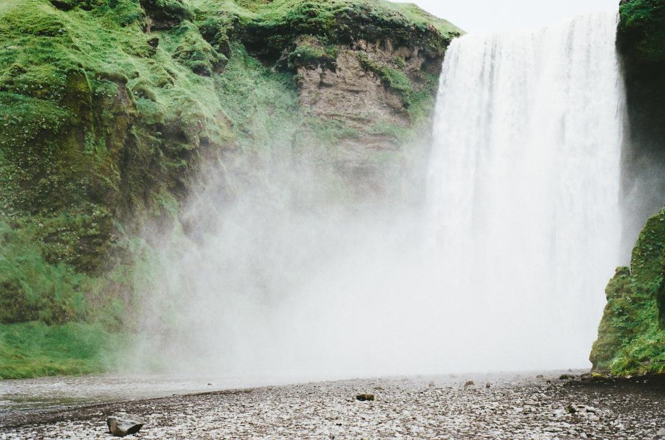 Free Image of Man Standing in Front of Waterfall 
