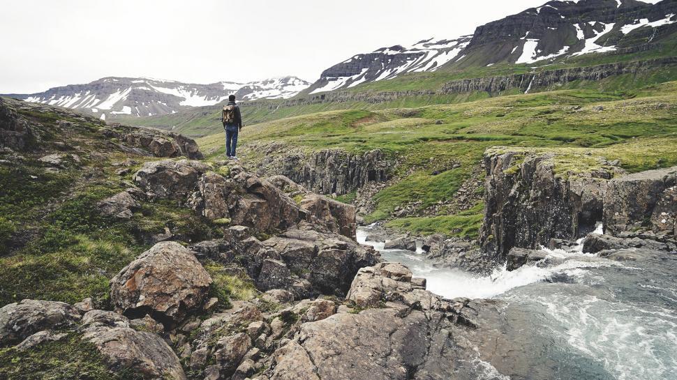 Free Image of Man Standing on Top of a Mountain by River 
