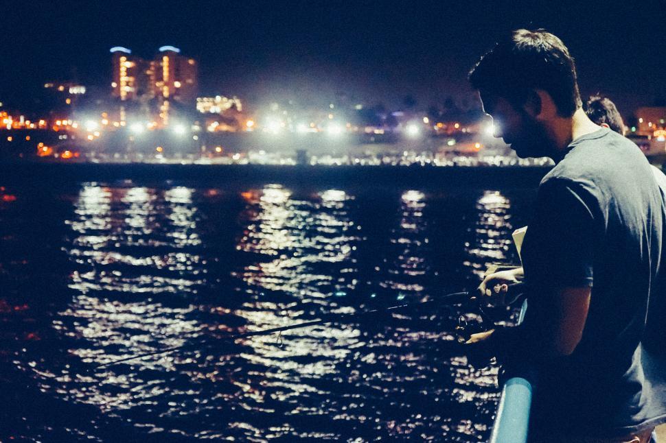 Free Image of Man Standing by Water at Night 