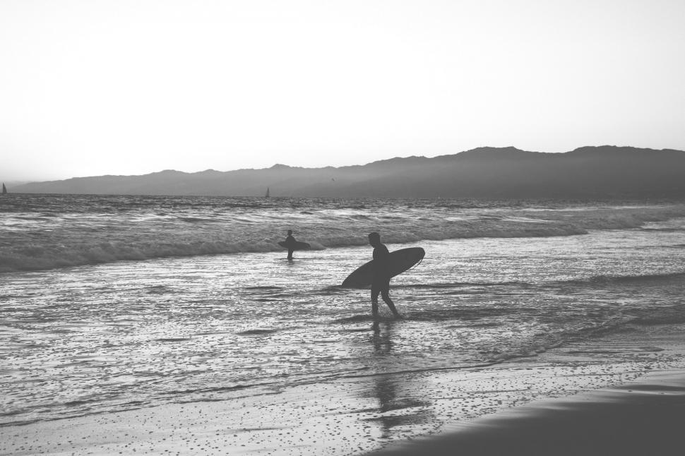 Free Image of Person Exiting Ocean With Surfboard 