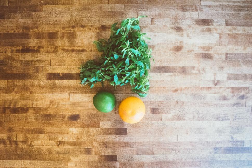 Free Image of Two Oranges and a Green Leaf on a Wooden Table 