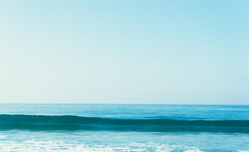 Free Image of Man Riding a Wave on a Surfboard 