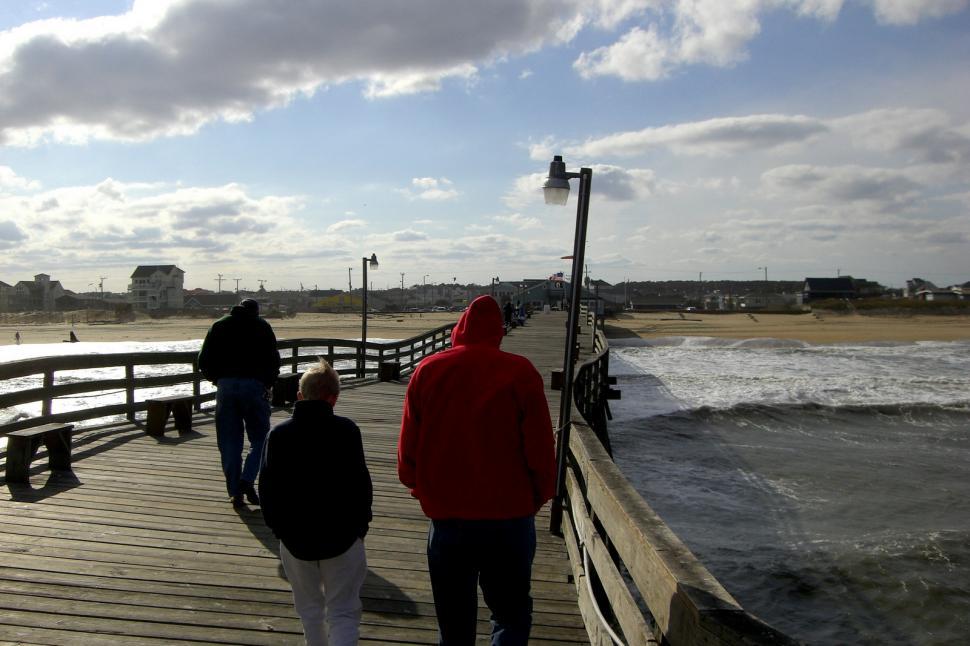 Free Image of Group of People Standing on Pier by Ocean 