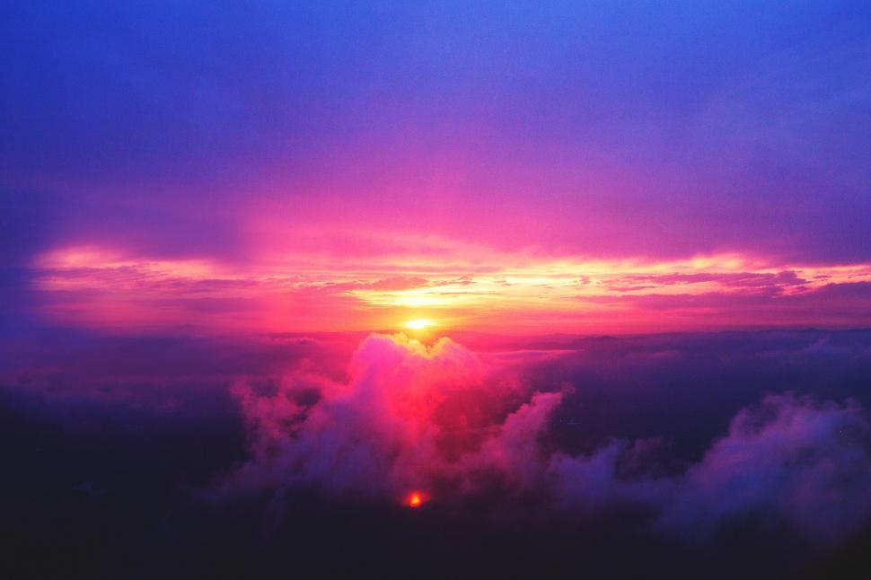 Free Image of Sun Setting Over Clouds in Sky 