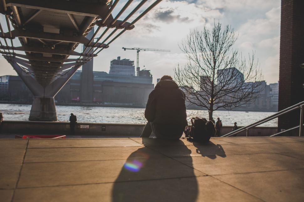 Free Image of Person Sitting on Bench by Water 