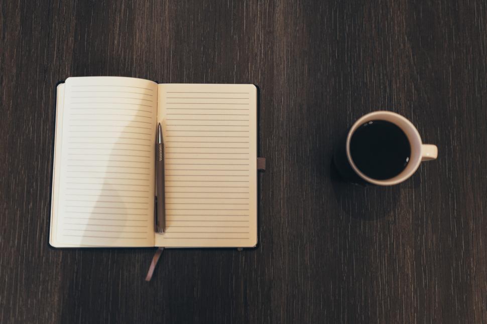 Free Image of A Cup of Coffee and a Notebook on a Table 