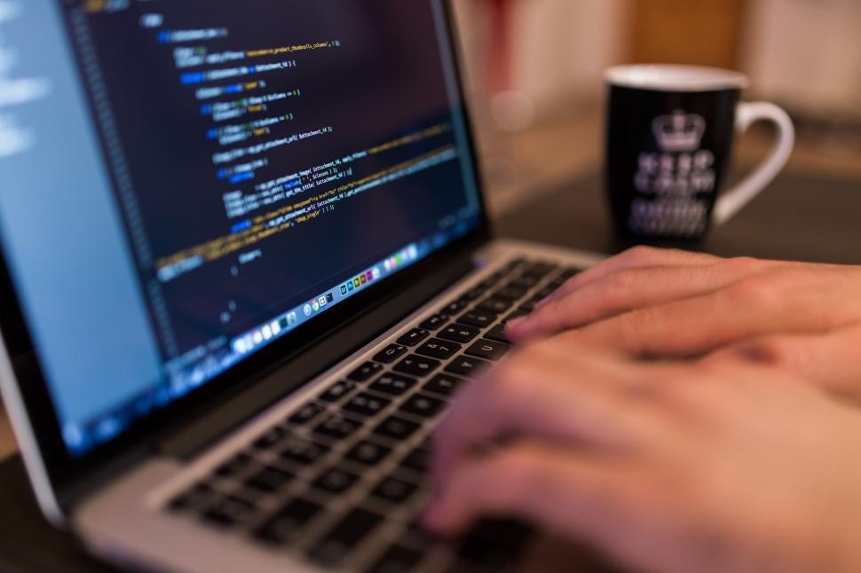 Free Image of Person Typing on Laptop With Cup of Coffee 