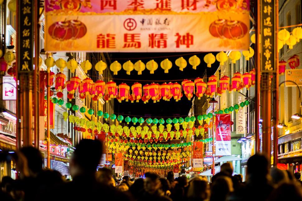 Free Image of Crowd of People Walking Down a Street Next to Tall Buildings 
