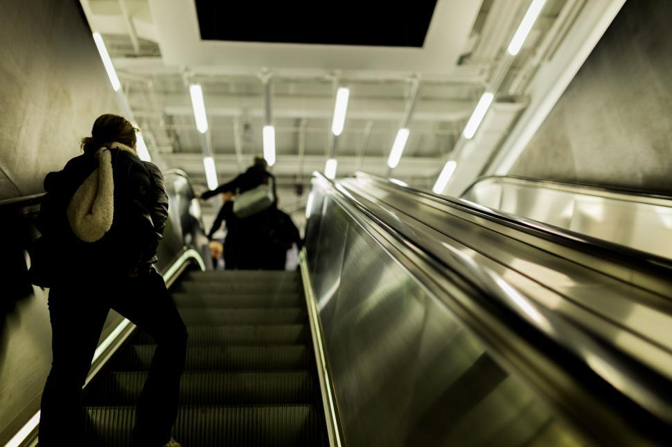 Free Image of Man Riding Escalator Down Flight of Stairs 