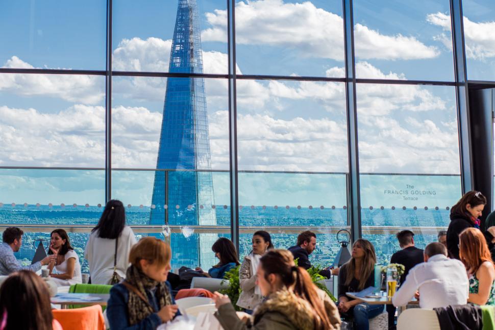 Free Image of Group of People Sitting at Tables in Front of Window 