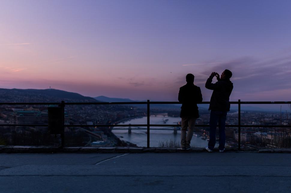 Free Image of Two Men Standing by Fence 