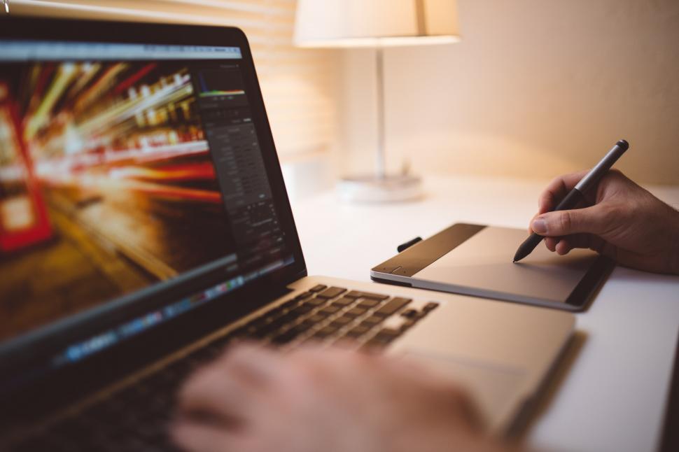 Free Image of Person Writing on Notebook While Using Laptop 