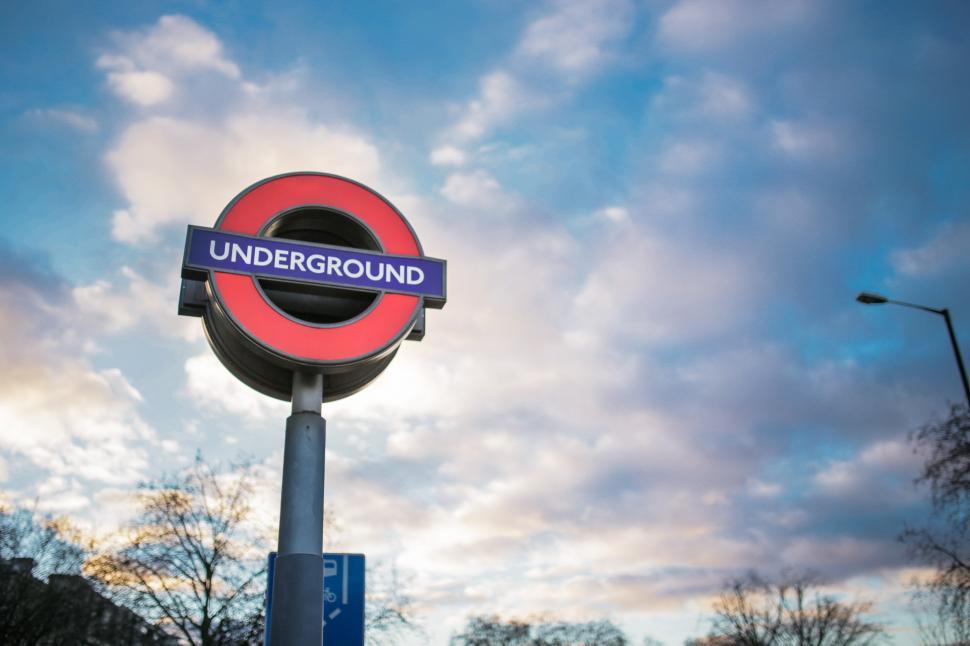 Free Image of Red and Blue Sign Under Cloudy Sky 