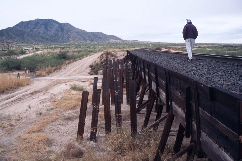 Free Image of Man walking along train tracks 
