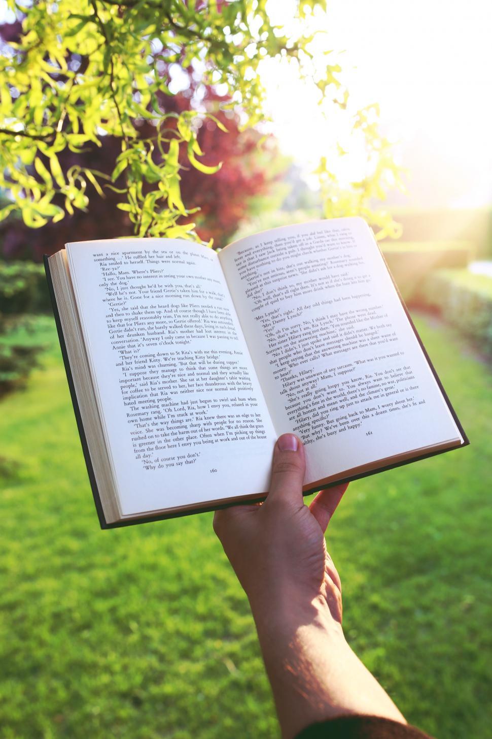 Free Image of Person Holding Open Book 