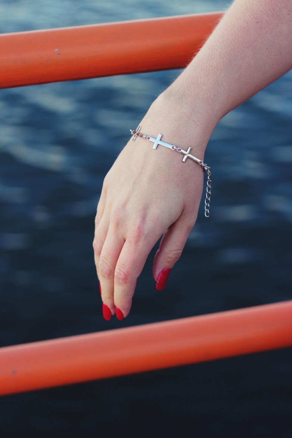 Free Image of Womans Hand With Cross Bracelet 