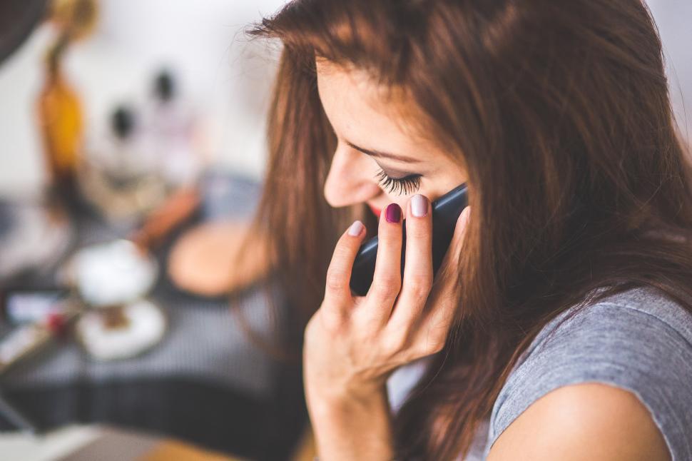 Free Image of Woman Talking on Cell Phone in Kitchen 