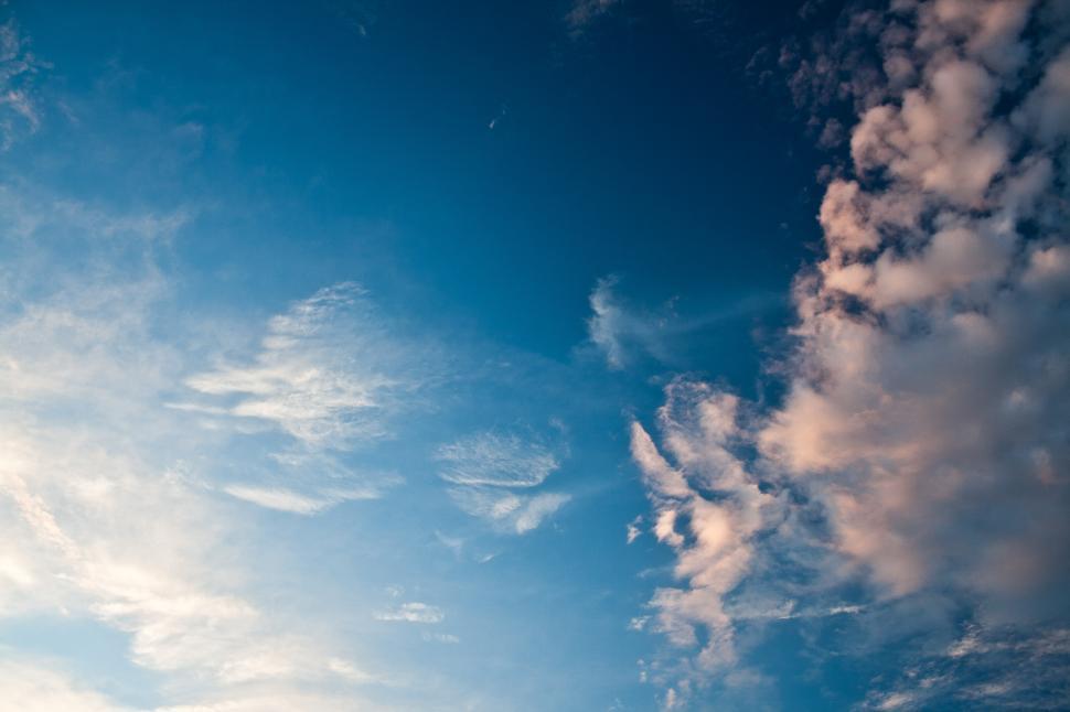 Free Image of A Plane Flying Through a Cloudy Blue Sky 