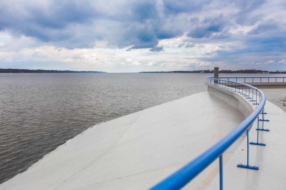 Free Image of Boat Traveling Down River Next to Large Body of Water 