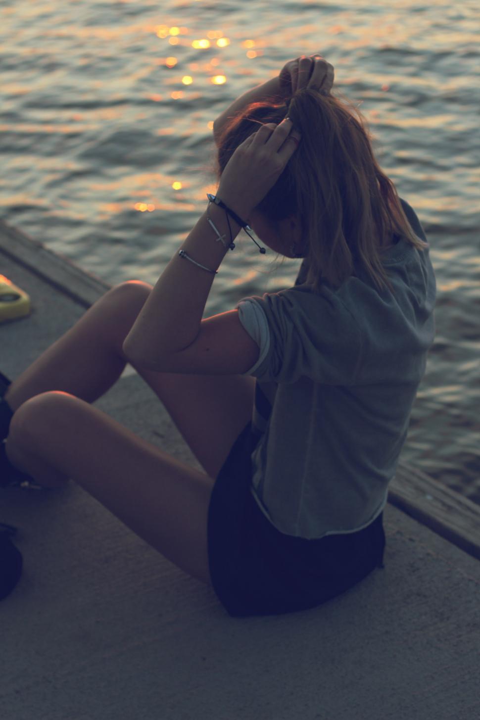 Free Image of Woman Sitting by Waters Edge 