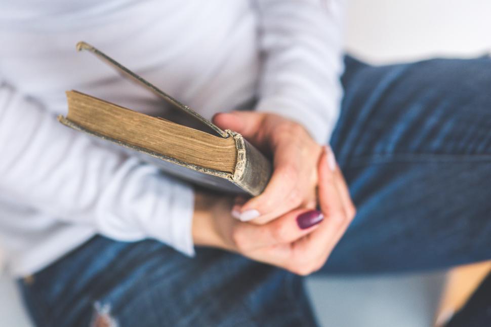 Free Image of Woman Sitting on Chair Holding Book 