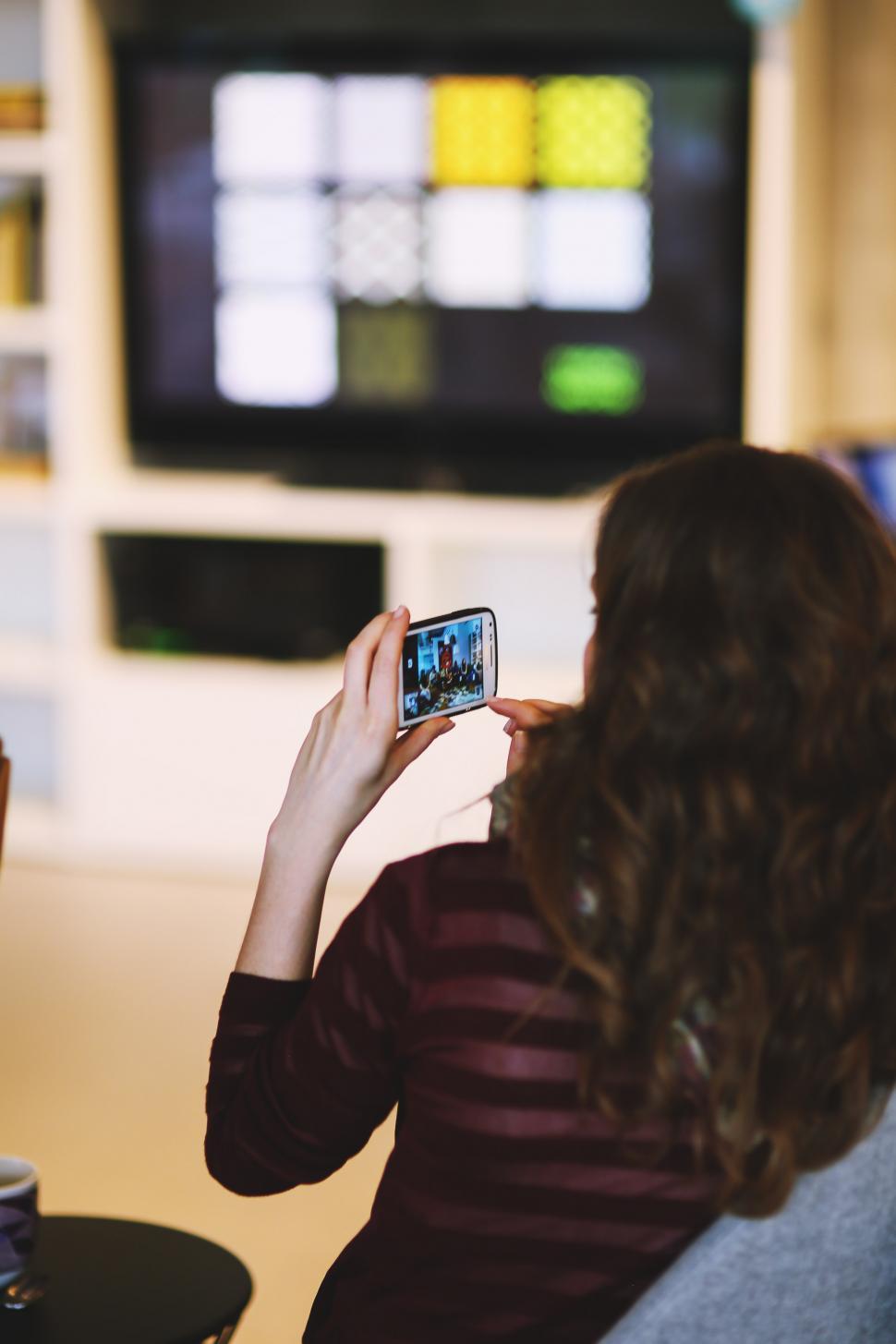 Free Image of Woman Taking Picture of Television 