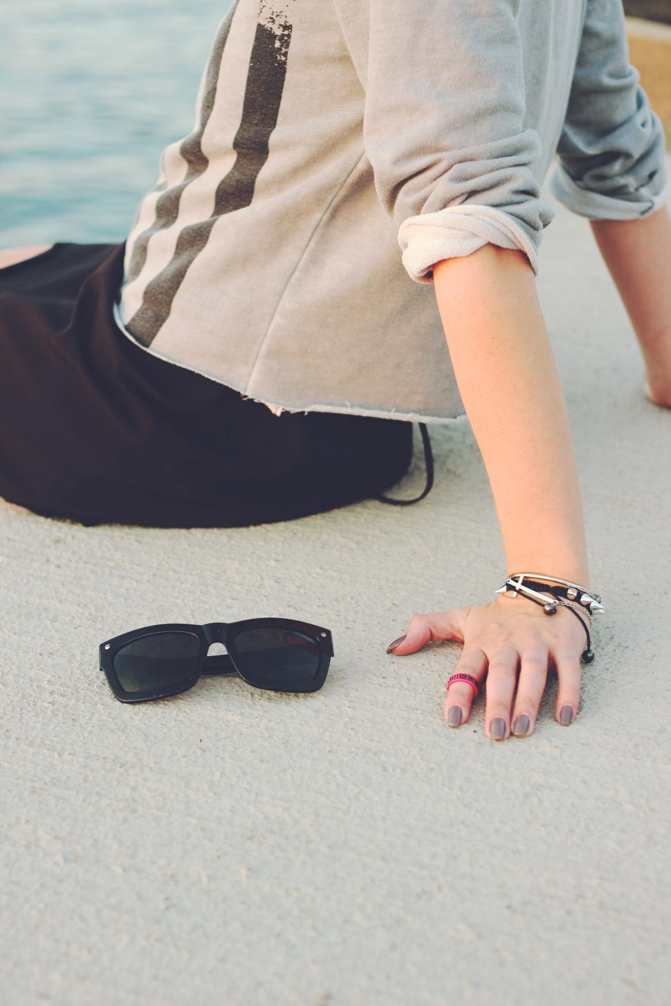 Free Image of Woman Sitting Next to Sunglasses 