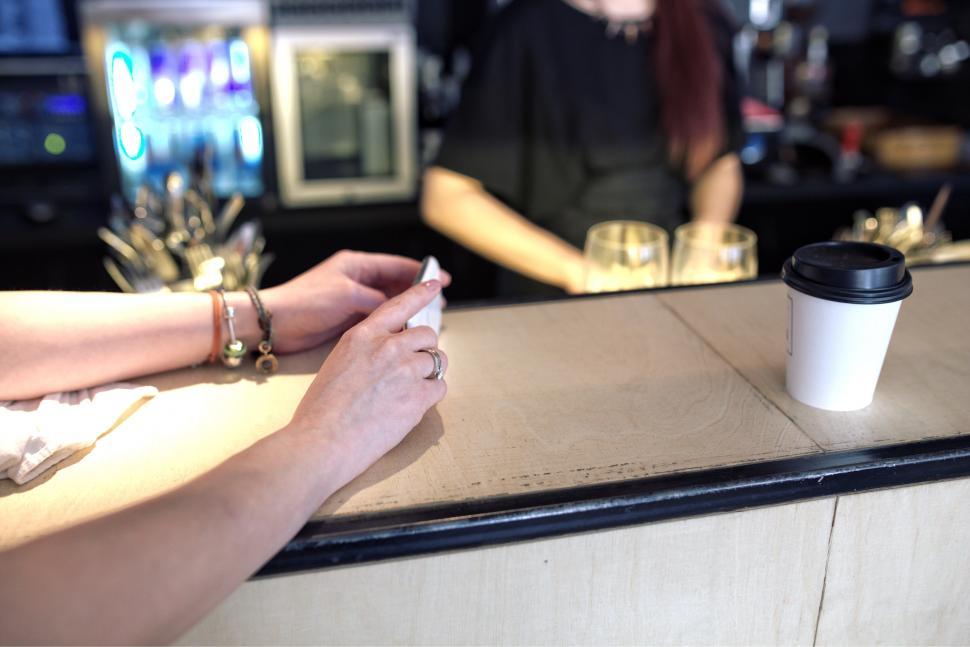 Free Image of Woman Sitting at Counter With Cup of Coffee 