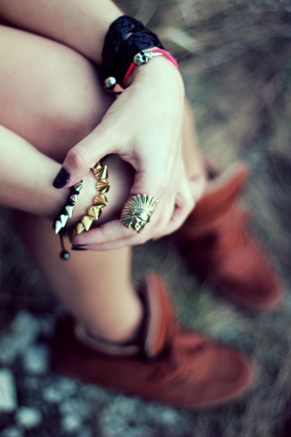 Free Image of Woman Sitting on Ground With Hands on Knees 