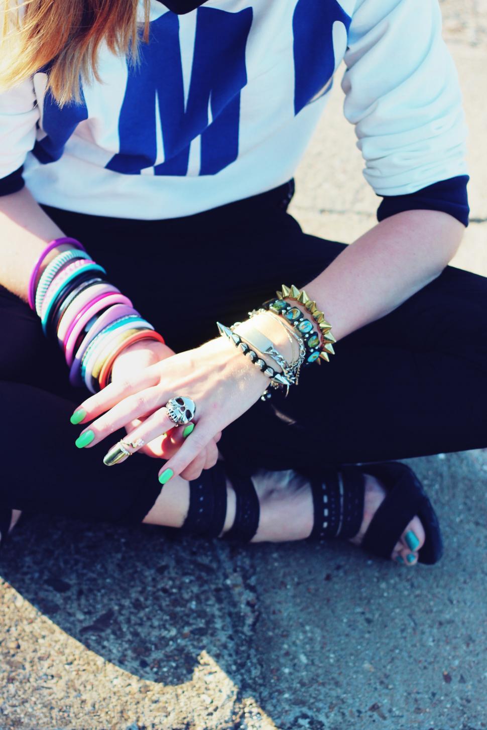 Free Image of Woman Sitting on Ground With Hands on Knees 
