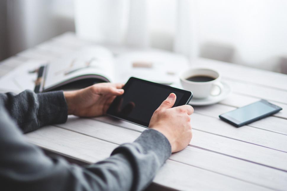 Free Image of Person Sitting at Table Using Tablet 