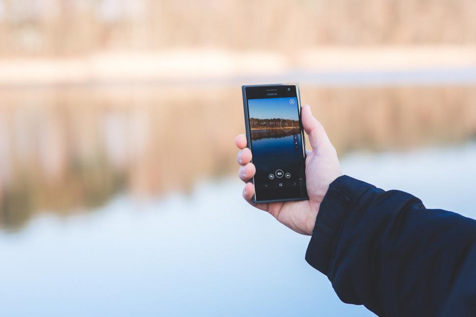 Free Image of Person Holding up Cell Phone by Water 