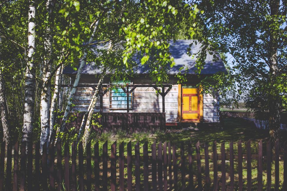 Free Image of White House With Yellow Door Surrounded by Trees 