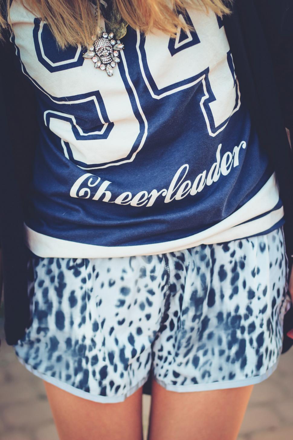 Free Image of Girl in Cheerleader Shirt and Leopard Print Shorts 