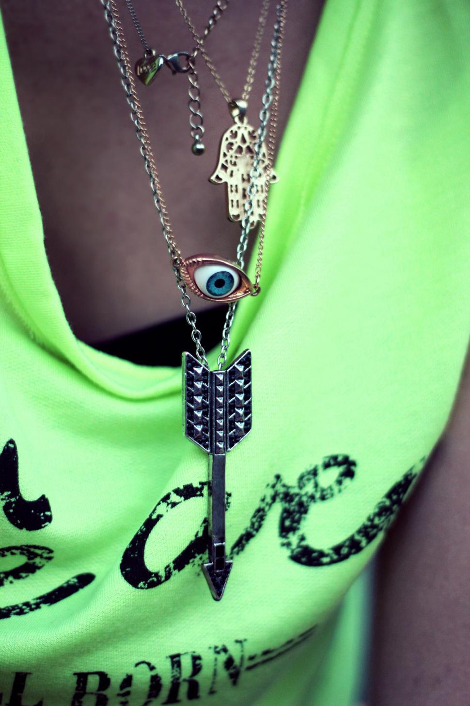 Free Image of Woman in Green Shirt and Arrow Necklace 