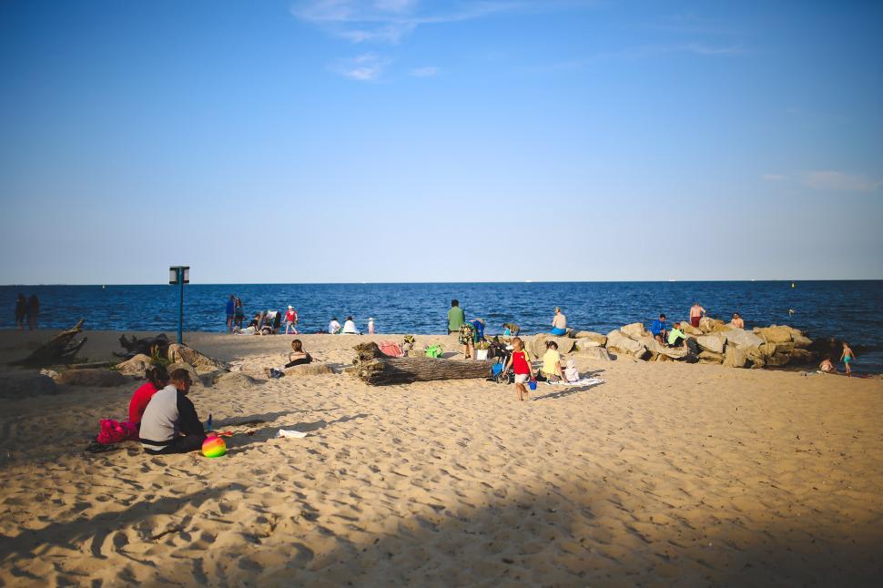 Free Image of Group of People Sitting on Top of Sandy Beach 