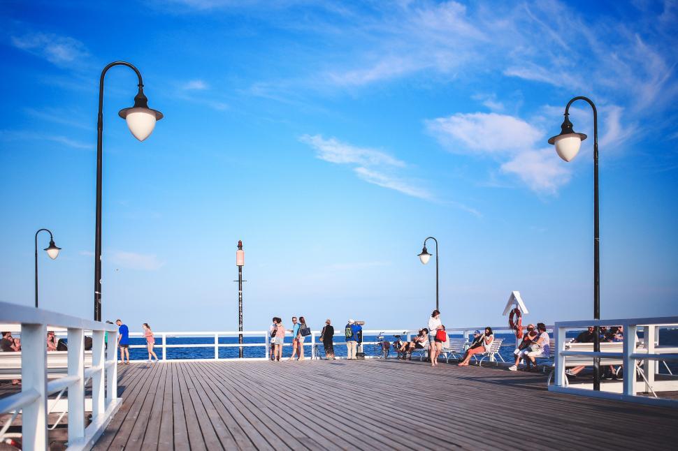 Free Image of Group of People Standing on Top of a Pier 
