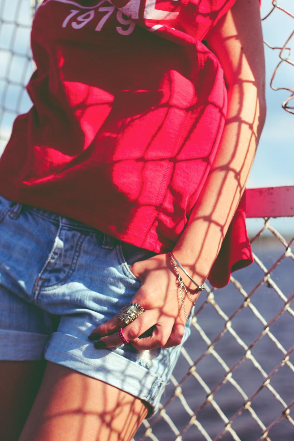 Free Image of Woman in Shorts and Red Shirt Holding Cell Phone 