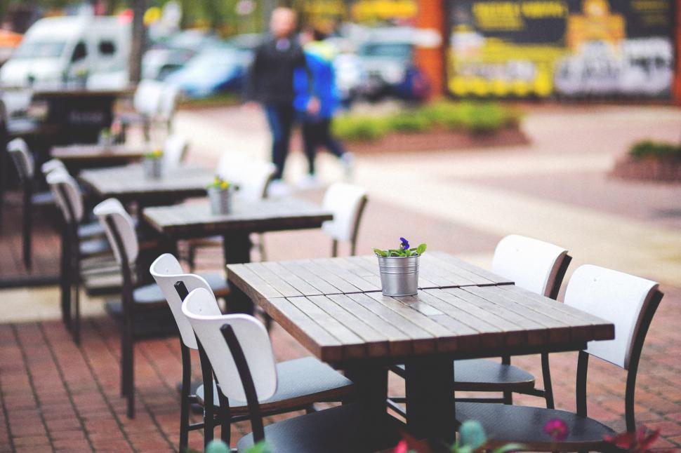 Free Image of Tables and Chairs Aligned on Brick Sidewalk 