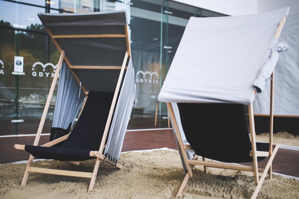 Free Image of Two Chairs Sit in the Sand 