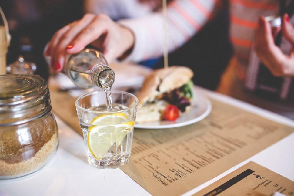 Free Image of Person Pouring Water Into Glass on Table 