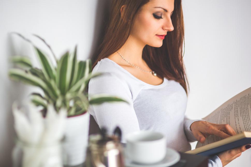 Free Image of Woman Reading a Book in a Kitchen 