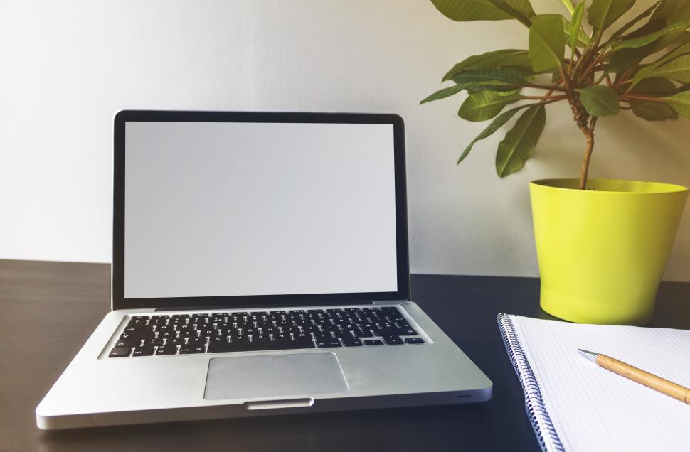 Free Image of Laptop with white screen and notebook on desk  