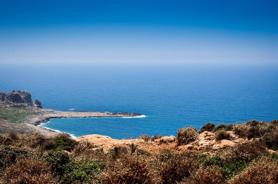 Free Image of Overlooking a Body of Water From a Hill 