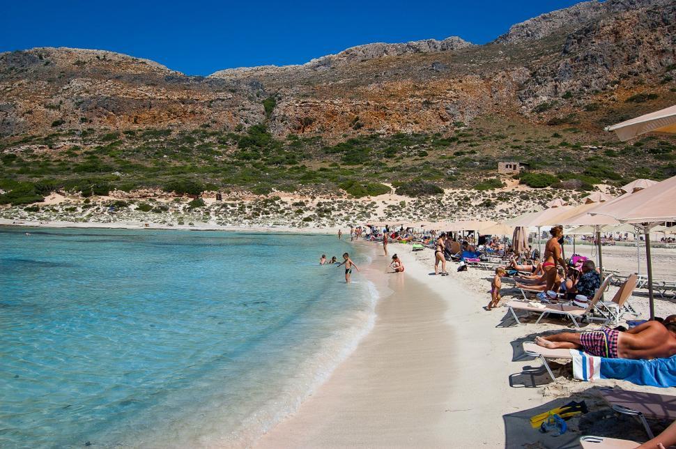 Free Image of Group of People Sitting on Sandy Beach 